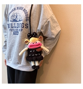 Close-up of handmade crochet funny character crossbody bag with pink lips and yellow hair