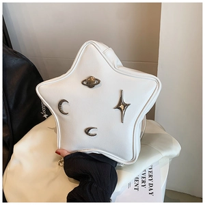 Detail of star-shaped white PU leather crossbody bag with silver celestial metallic charms