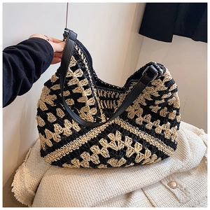 Close-up of black and white crochet floral shoulder bag with adjustable leather strap