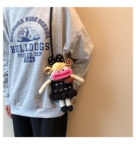 Detail of handmade crochet cartoon doll bag with pink lips and black knit dress
