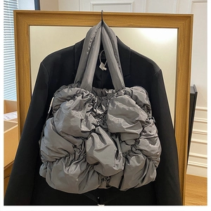 Gros plan d'un sac cabas matelassé gris avec une texture de tissu en nylon plissé
