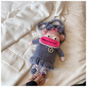 Détail d'un sac bandoulière au crochet avec collier de perles et visage mignon