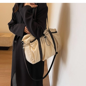 Detail of water-resistant nylon tote bag with black drawstring and adjustable strap