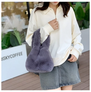 Close-up of fluffy faux fur handbag in deep purple featuring a soft handheld design