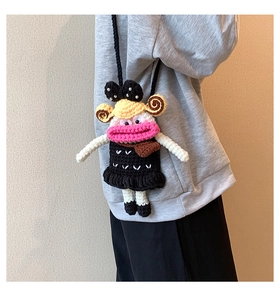 Close-up of handmade crochet bag featuring a cartoon doll design with pink lips