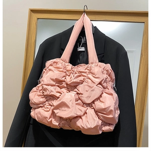 Détail de la texture froncée rose sur un sac cabas en nylon matelassé moderne