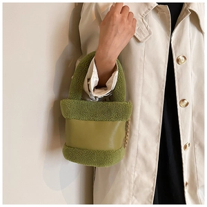 Detail of avocado green plush and leather bucket bag with golden chain strap for women