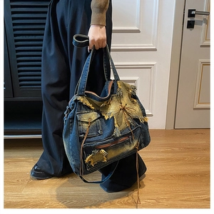 Detail einer Vintage-Denim-Tasche mit ausgefransten Kanten und funktionalen Taschen