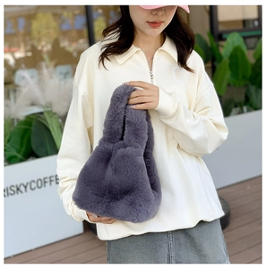 Detailed view of the soft faux fur texture on a plush deep grey-purple bucket handbag