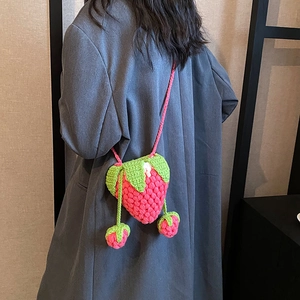 Handmade crochet strawberry crossbody bag in pink yarn with green leaf detail