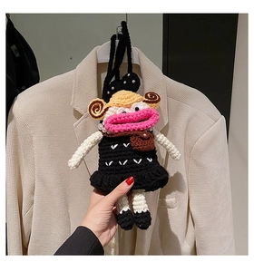 Detailed close-up of handmade crochet bag charm with pink lips and black polka dot dress