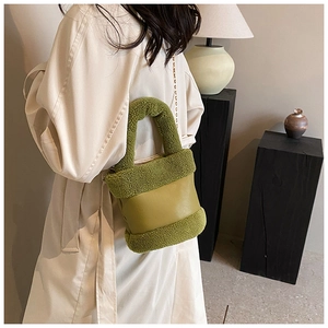 Detail of green faux fur and leather bucket bag with golden chain strap on a model
