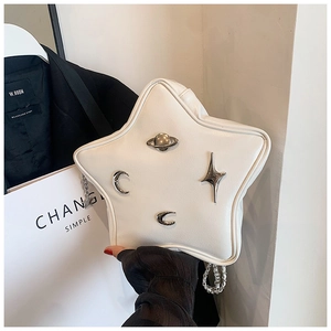 Detail of star-shaped crossbody bag with metallic moon and planet charms and chain