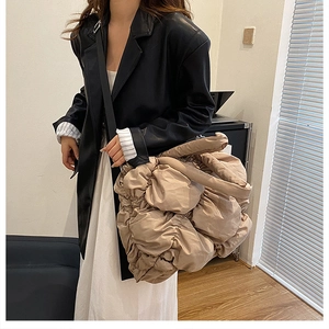 Détail d'un grand sac cabas beige matelassé avec texture froncée sur un mannequin