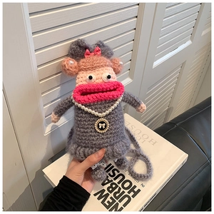 Vue détaillée du sac singe fait main au crochet avec lèvres roses et collier de perles