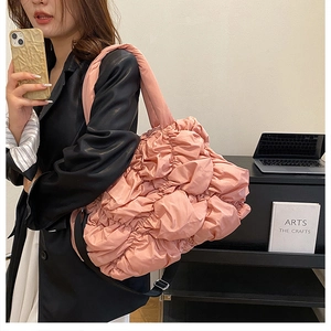 Détail du sac cabas rose en nylon matelassé avec texture gaufrée et bandoulière réglable