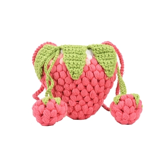Handmade crochet strawberry crossbody bag in pink cotton with green leaf strap detail