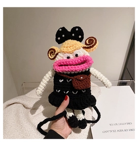 Detail of handmade crochet monster crossbody bag with pink big lips and pearl bow detail