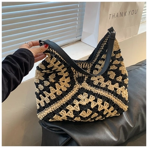 Detail of the woven texture and black leather strap on a large crochet tote bag