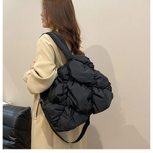 Détail du sac cabas en nylon matelassé noir montrant la texture plissée et la bandoulière