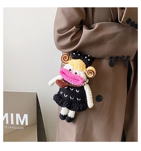 Close-up of handmade crochet doll accessory with pink lips and pearl necklace detail