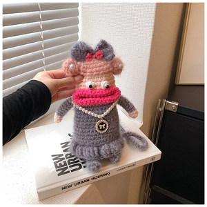 Détail d'étui de téléphone en tricot avec lèvres roses, collier de perles et nœud