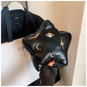 Detail of a star-shaped black shiny PU leather bag with silver metal star and moon charms