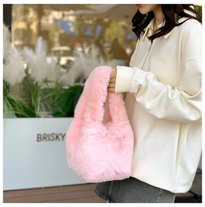 Detailed close-up of a pink faux fur handbag with a soft, fluffy texture for winter