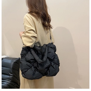 Détails macro d'un grand sac bandoulière noir matelassé avec texture plissée en nylon
