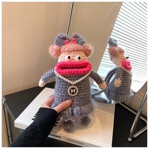 Détail d'un sac à téléphone au crochet avec grande bouche rose et collier de perles