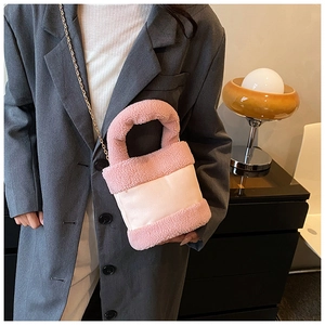 Detail of pink faux fur and leather patchwork bucket bag with golden chain strap