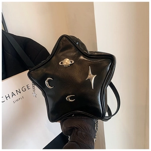 Detail of star-shaped black faux leather shoulder bag with silver metal cosmic charms