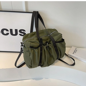 Detail of army green nylon tote bag featuring functional drawstring pockets and buckle straps