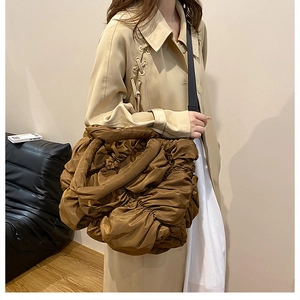 Détail d'un sac nuage plissé marron avec texture en nylon doux et bandoulière réglable