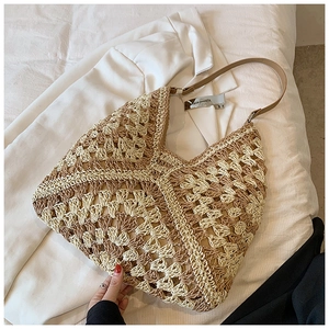 Detailed close-up of handmade crochet straw shoulder bag with contrast diamond pattern