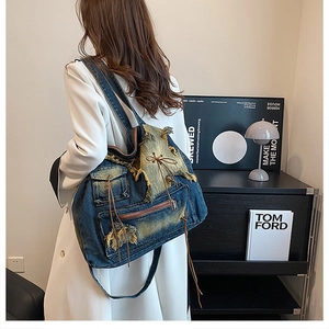 Detailansicht der Vintage-Jeans-Tasche mit abgenutzten Kanten und Metallreißverschlüssen