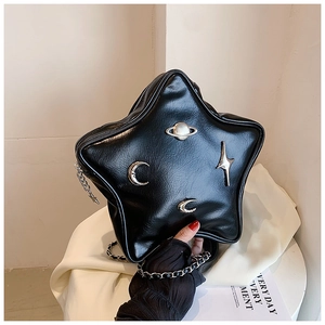 Close-up of star-shaped crossbody bag with silver celestial moon and planet ornaments