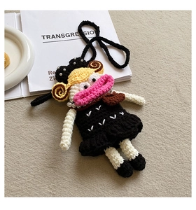 Detail of handmade crochet doll bag with large pink lips and yellow spiral hair detail
