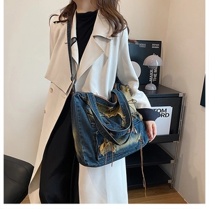 Detailansicht der Vintage-Jeanstasche mit destroyed-Effekten und langen Fransen
