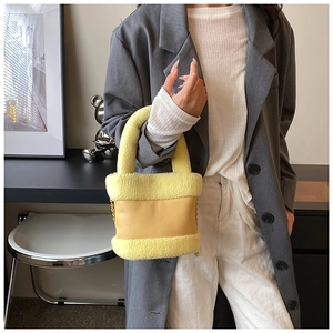 Detail of yellow plush fleece and leather bucket bag with chain strap and handle