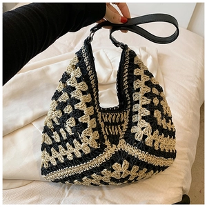 Close-up of contrast woven tote bag with black leather straps and bohemian texture