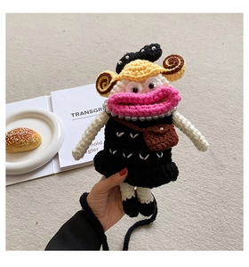 Detailed view of handmade crochet doll bag featuring pink lips and black woven strap