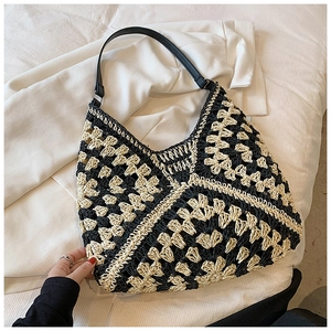Detail of hand-woven crochet shoulder bag featuring black and white contrast knit pattern