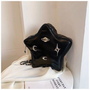 Detail of star-shaped black bag with metallic celestial charms and chain strap