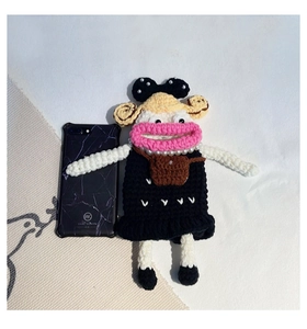 Detail of handmade crochet big mouth doll bag showing pearl necklace and marble phone case