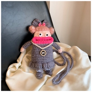 Détail du sac singe au crochet fait main avec lèvres rouges et collier de perles sur soie