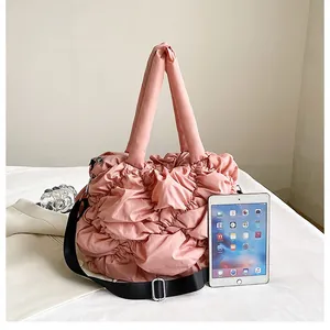 Détail du sac fourre-tout matelassé rose avec bandoulière réglable et tissu en nylon léger
