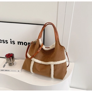 Detail of suede tote bag with white shearling trim and adjustable leather strap
