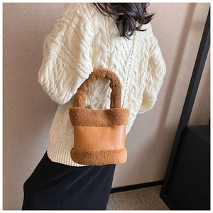 Close-up of caramel plush bucket bag with leather patchwork and gold chain strap