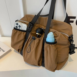 Detail of brown nylon functional bag with multi-pocket storage and black straps